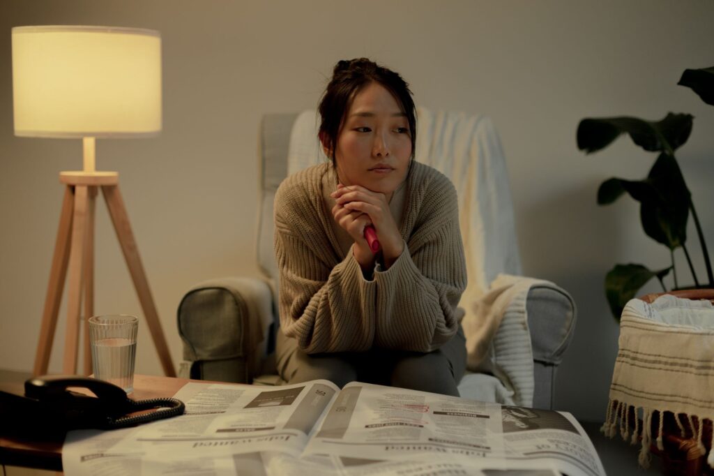 一人で座り不安げに考え込む女性