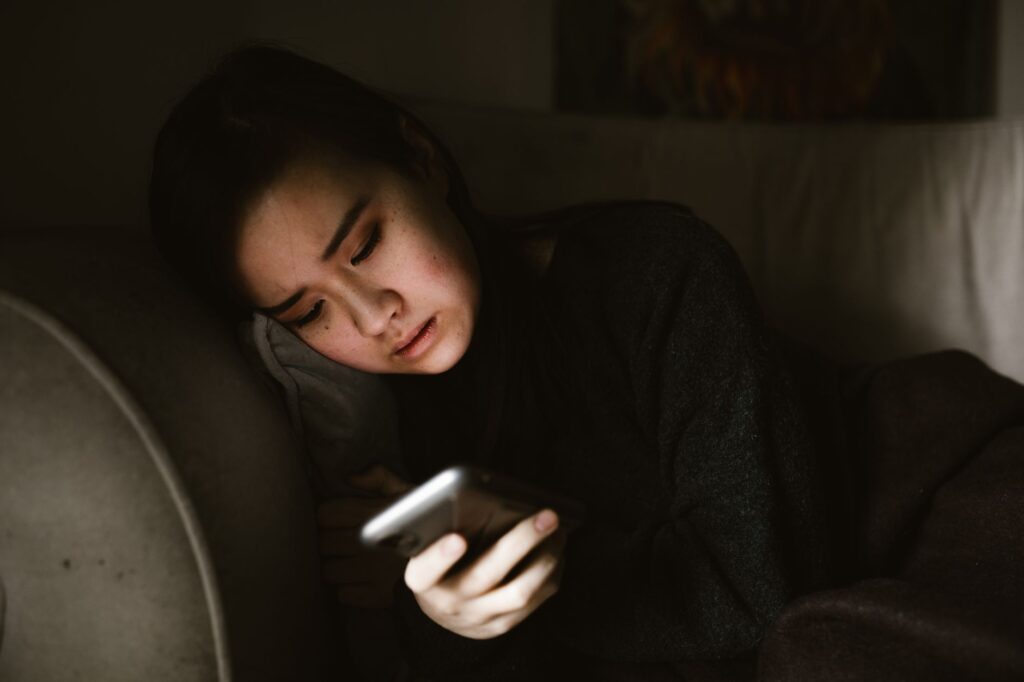 夜、スマートフォンを使いほっとした表情の女性