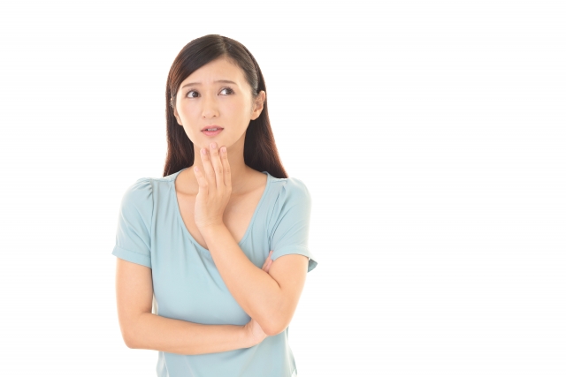 スマートフォンで転職サイトを不安そうに眺める女性