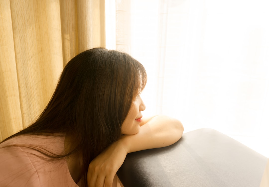 窓の外を見つめながら将来を考え込む女性