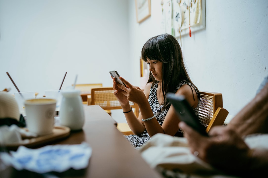 スマートフォンを見ながら占い結果に戸惑う女性