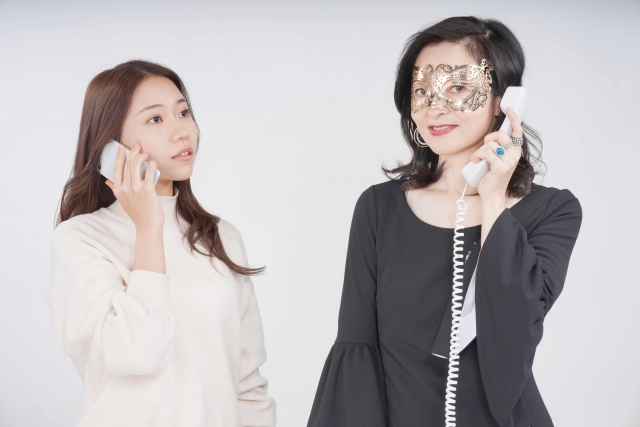 スマートフォンでサービスを比較検討する女性